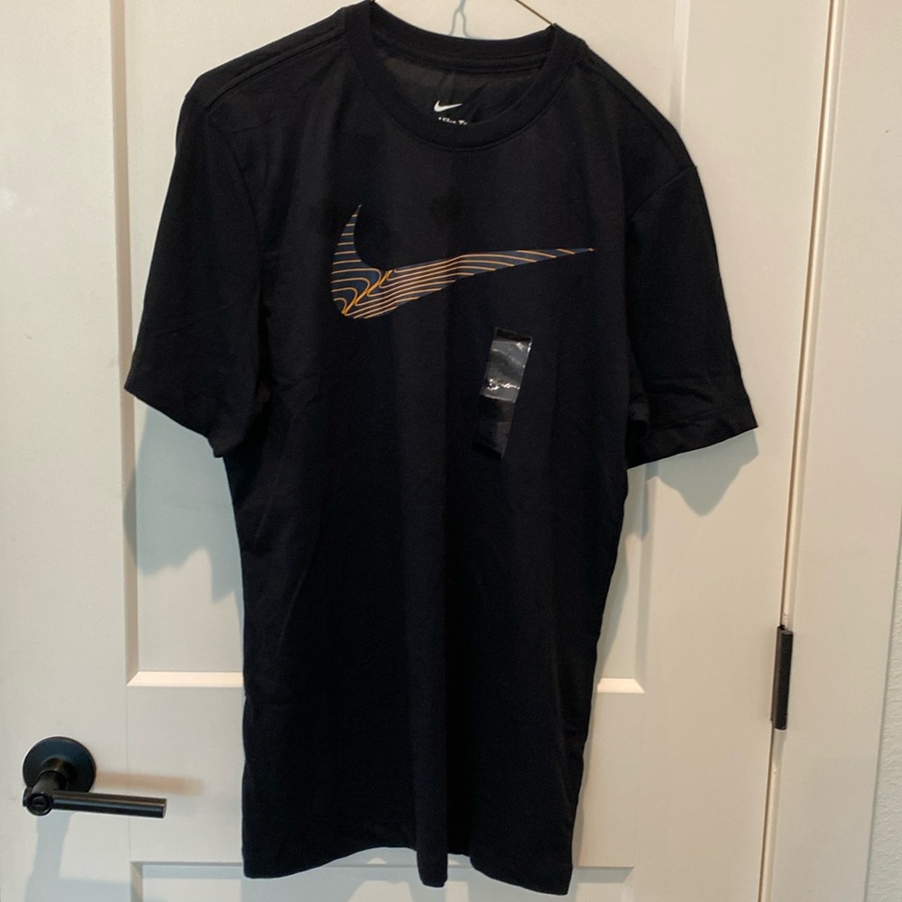 The Nike Tee. Yellow/grey Nike swoosh across the front.